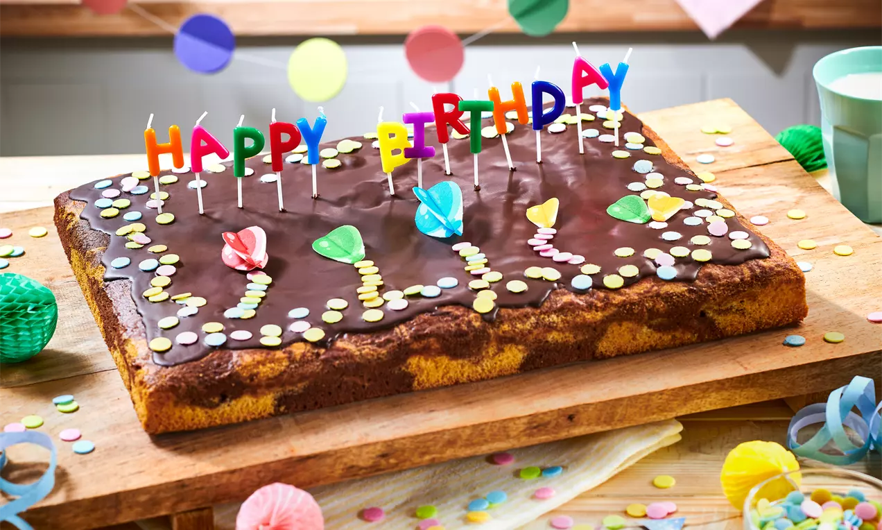 Marmorkuchen vom Blech – einfaches Rezept für saftigen Rührkuchen mit hellem und dunklem Teig, ideal als Geburtstagskuchen für viele Gäste. Schnell gebacken und lecker verziert.