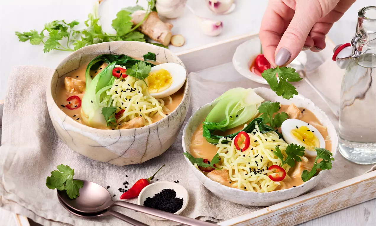 Creamy Ramen Soup serviert in Schalen mit zartem Hähnchen, cremiger Kokosmilch, frischem Pak Choi, Nudeln und Crème fraîche – leicht scharf und voller Geschmack für ein wärmendes, asiatisch Gericht.