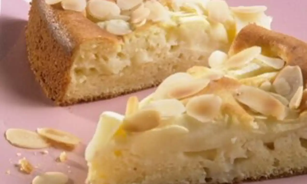 Zwei Apfelkuchenstücke mit goldbrauner Kruste und saftiger Füllung, bedeckt mit hellen Mandelblättchen auf einem rosa Teller
