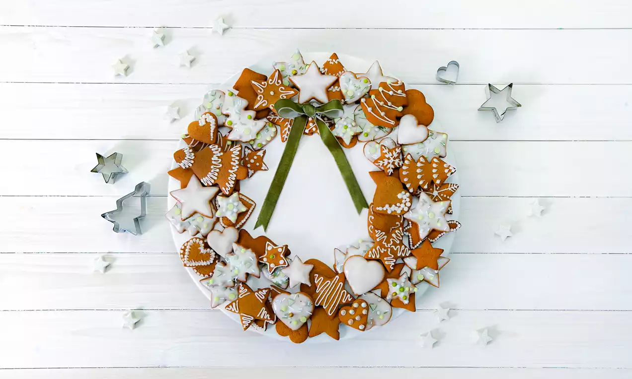 selbstgemachte Lebkuchen-Kekse, mit Gewürzen und Honig verfeinert und mit Zuckerguss und Zuckerschrift besonders festlich dekoriert und als Adventskranz gelegt.