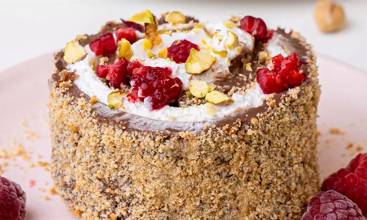 Kremaste čokoladne rolnice sa podlogom od keksa, bogatim filom od tamne čokolade i nežnim slojem šlaga, posute hrskavim pistaćima i osvežavajućim malinama.