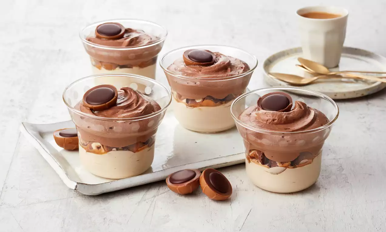 Toffifee®-Dessert im Glas mit cremiger Schokoladen- und Karamellschicht, ganzen Toffifee®, gehackten Haselnüssen und Sahne
