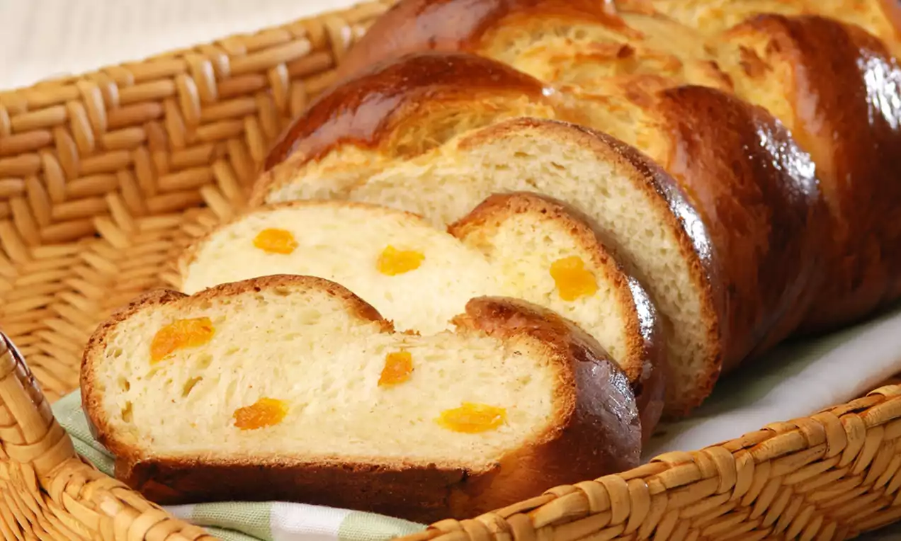 Altın sarısı parlak yüzeyli, örgü şeklinde kayısılı çörek dilimleri hasır bir sepette düzenlenmiş şekilde sunulmuş