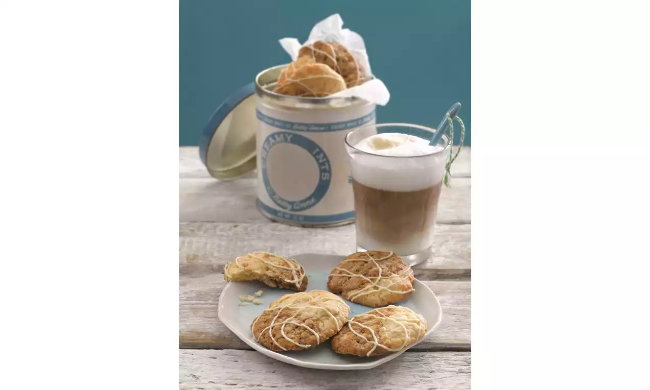 Café irlandais dans un verre transparent avec une mousse blanche onctueuse, accompagné de biscuits dorés glacés sur une assiette blanche