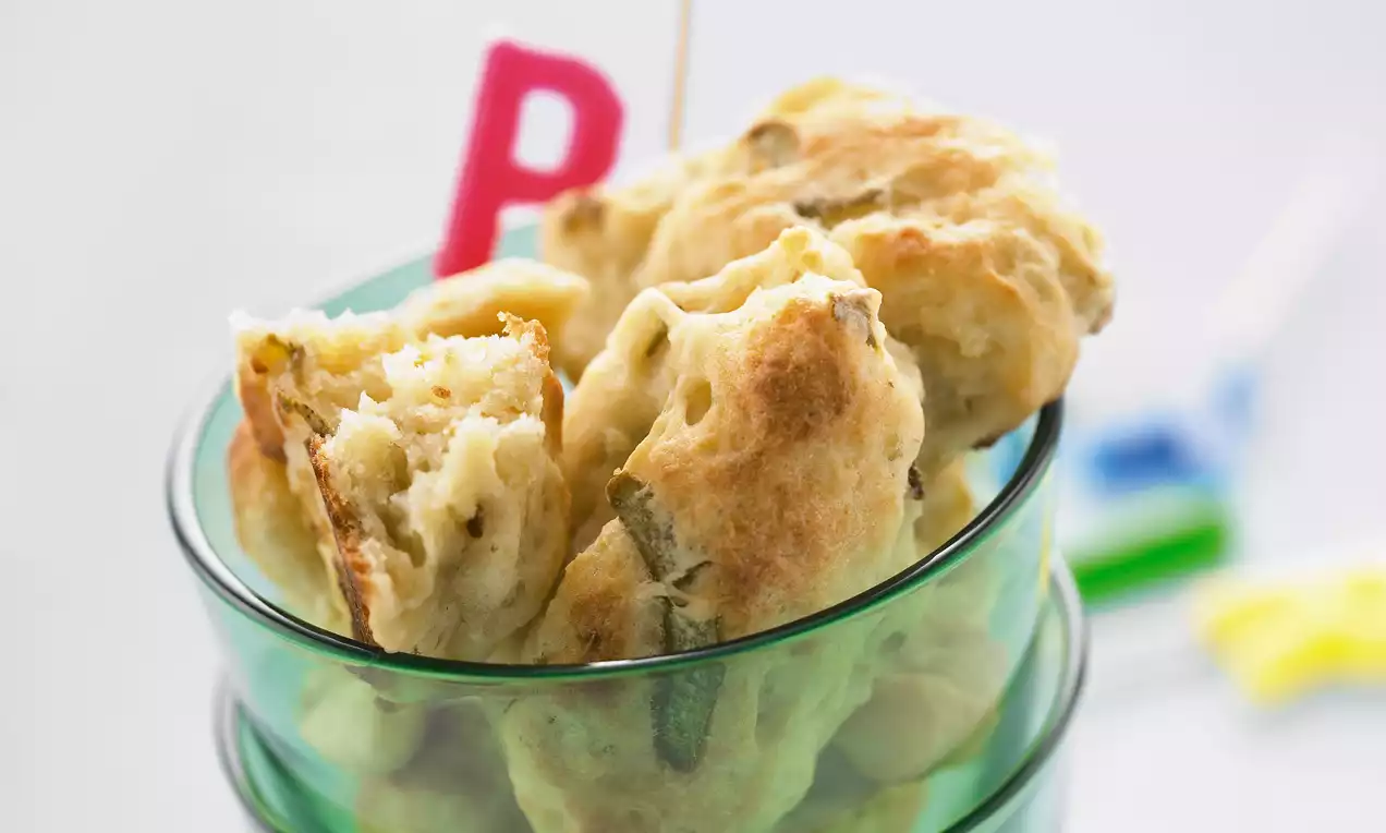 Petits amas dorés et moelleux avec des morceaux visibles de poire, servis dans un verre transparent décoré d’un cure-dent rouge