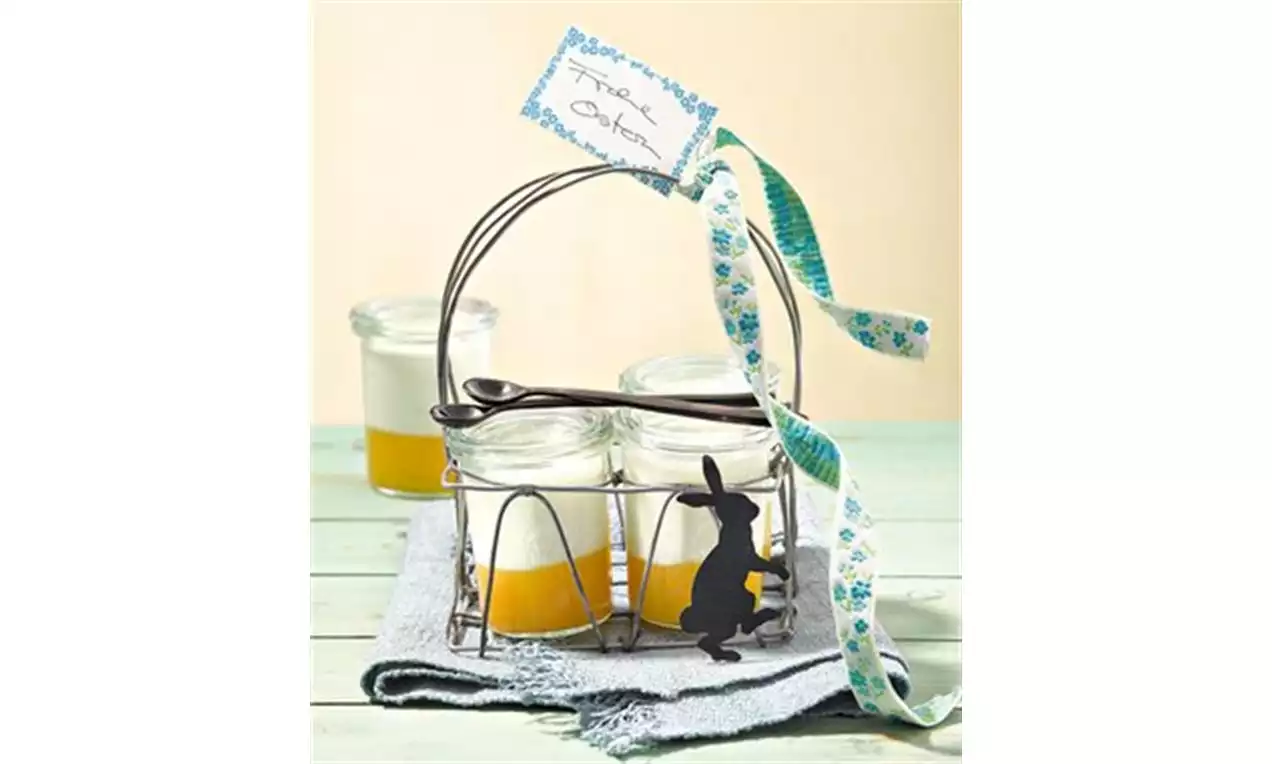 Mousses au yaourt blanc et purée passion jaune vif dans des pots en verre disposés dans un panier métallique avec ruban fleuri
