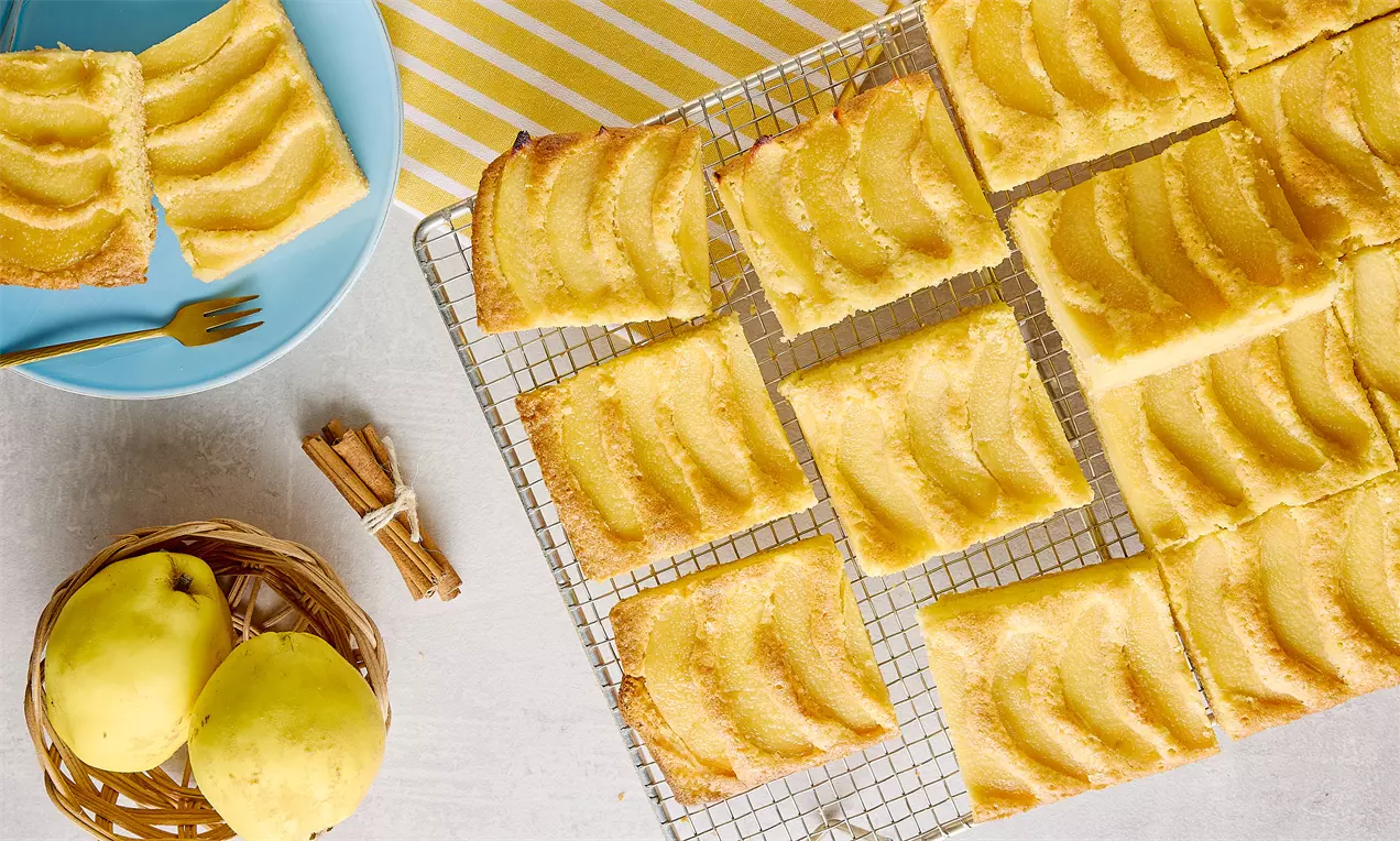 Dilimli ayva turta altın rengi hamur tabanı üzerinde sıralı ince ayva dilimleriyle tel ızgara üzerinde düzenlenmiş şekilde sunulmuş