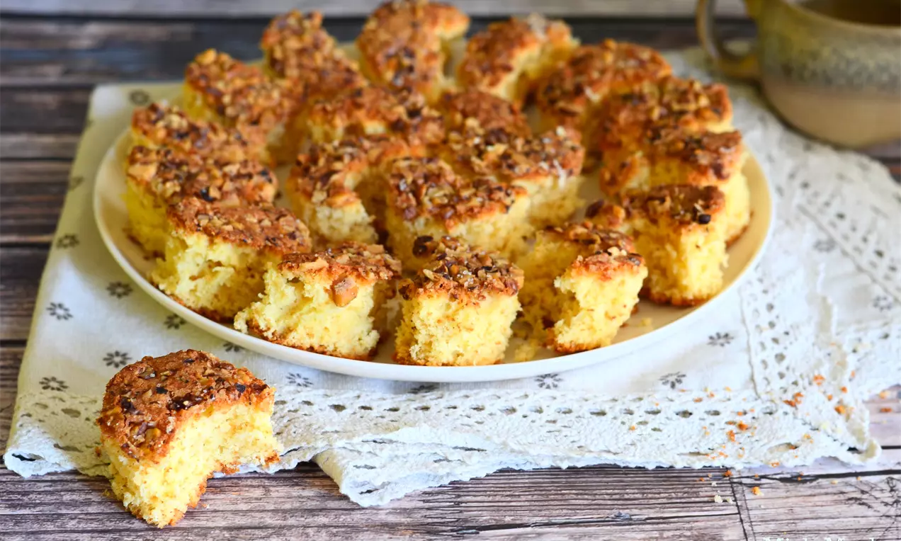 Златисти английски кексчета с хрупкава орехова кора, подредени небрежно върху бяла чиния върху ленена салфетка с дантела