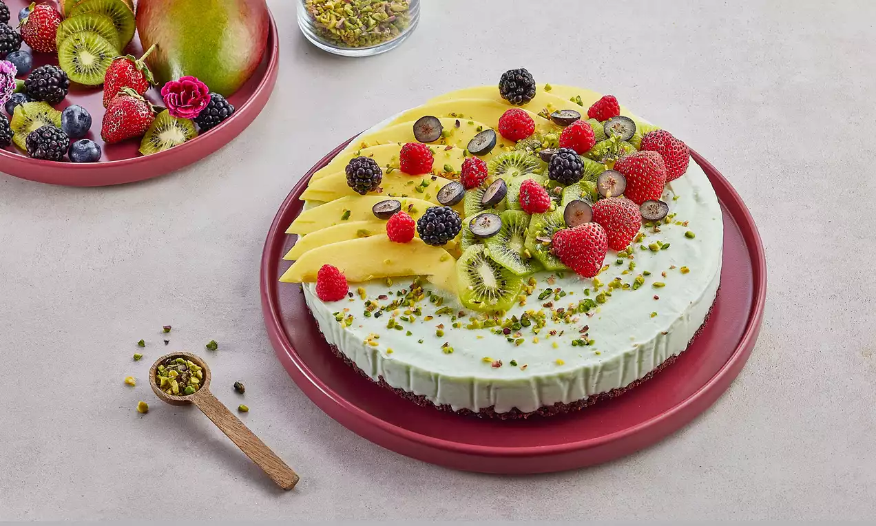 Beyaz krema dolgulu parfe tabanı antep fıstığı kırıklarıyla süslenmiş, üstü mango dilimleri, kivi, ahududu ve böğürtlenle düzenlenmiş