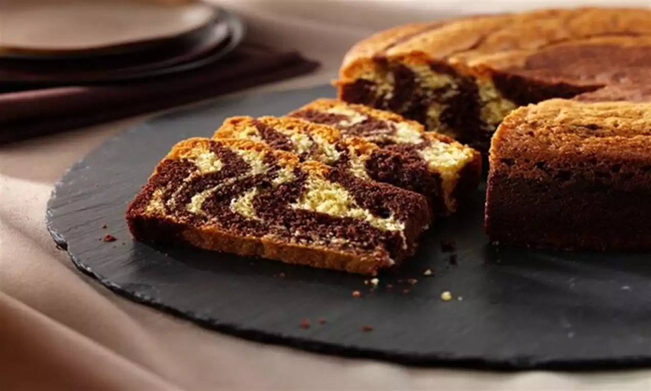 Feliile de chec Zebra cu model marmorat ciocolatiu și vanilat, așezate pe o tavă rotundă neagră într-un decor cald de dining