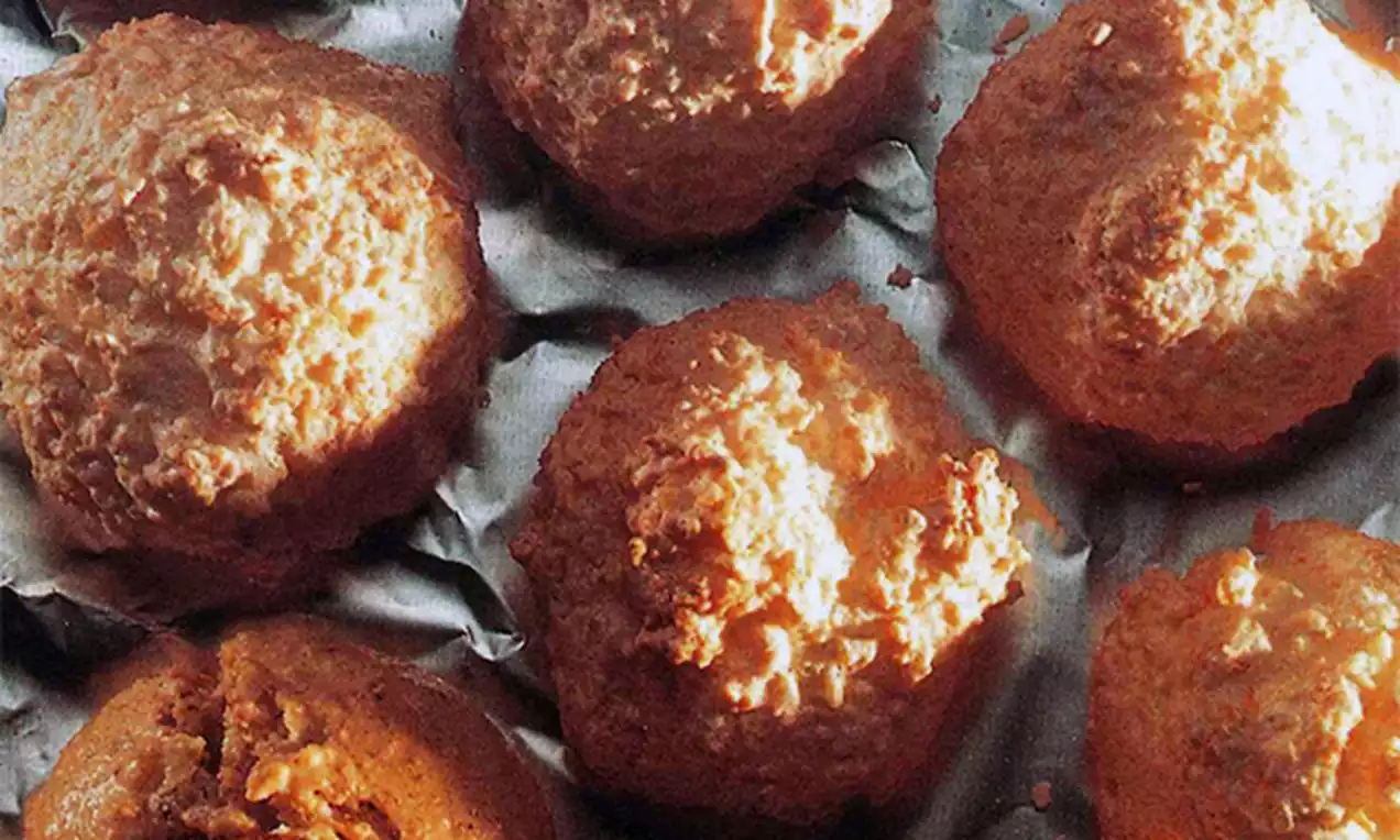 Petites montagnes dorées à la texture granuleuse et légèrement irrégulière, disposées sur une feuille de papier cuisson froissée