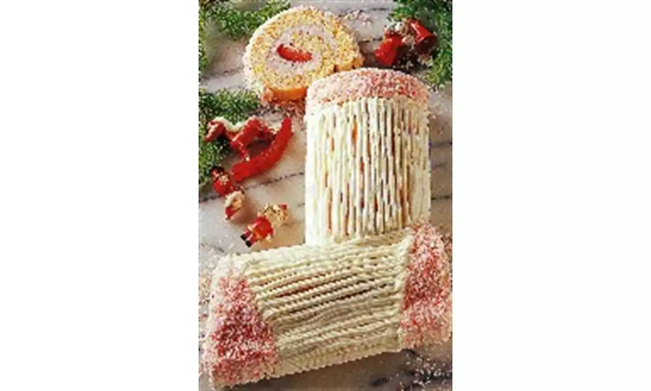 Witte roomtaartsok met ribbelstructuur, roze kristalsuiker aan de randen, op een marmeren ondergrond met groene dennentakken en snoepdecoratie