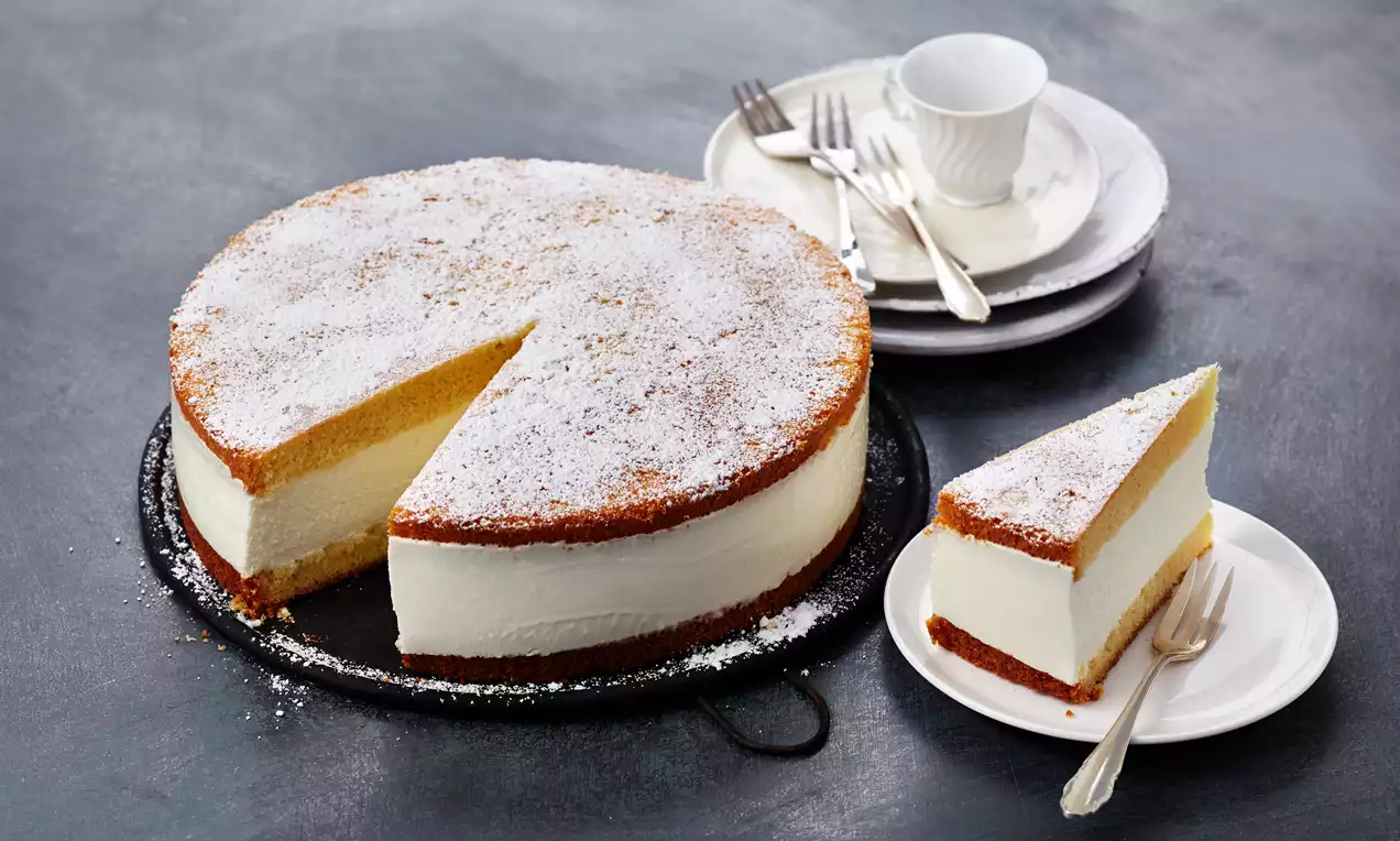 Torta iz skute in smetane s svetlim, kremastim nadevom.