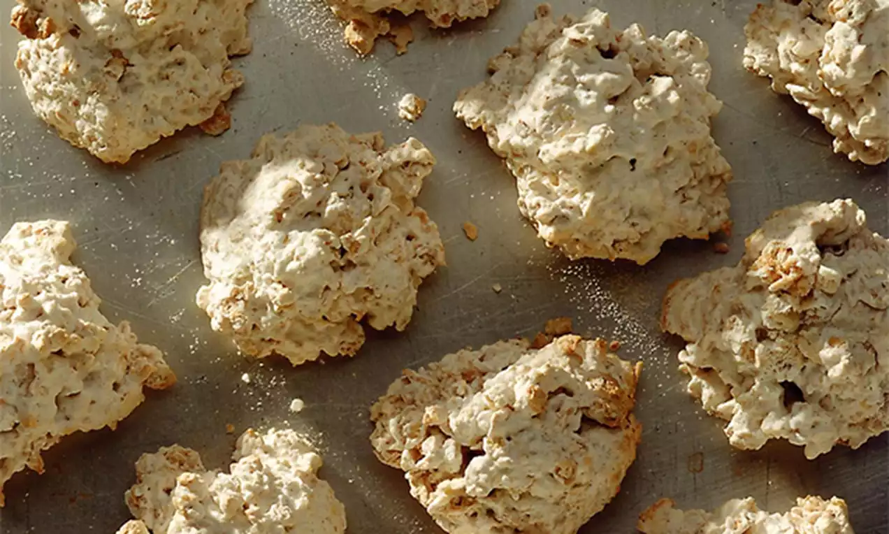 Biscuits à l'avoine dorés et irréguliers, à la texture rugueuse et croquante, disposés sur une plaque de cuisson argentée