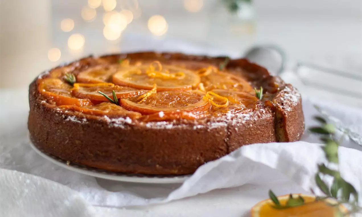 Upside-Down-Kuchen mit kandierten Orangen auf einer Servierplatte – saftiger Rührteig mit karamellisierten Orangenscheiben, glänzendem Sirup und festlicher Dekoration, perfektes Dessert für Weihnacht.