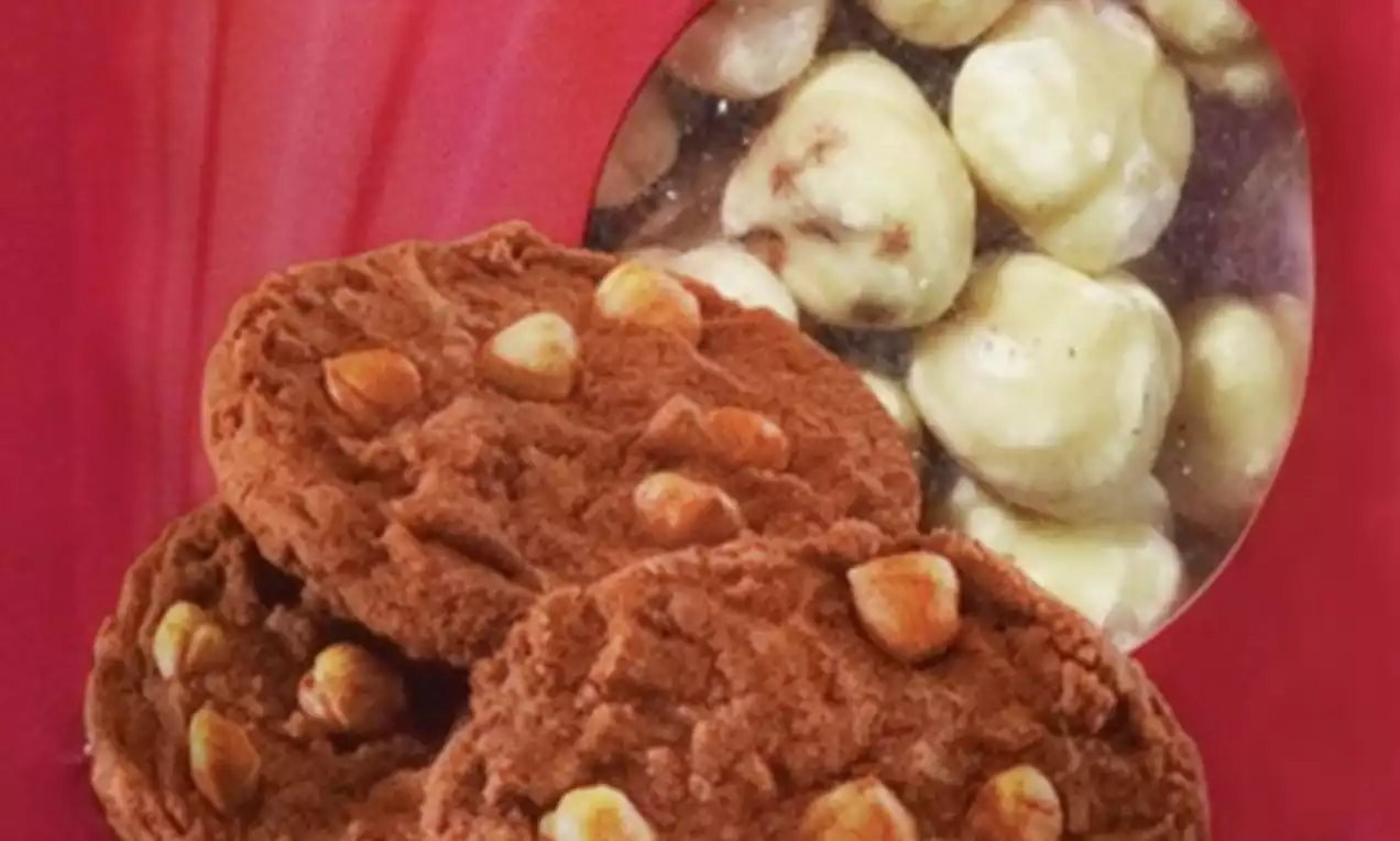 Bruin gebakken koekjes met lichtgekleurde hazelnootstukjes, voor een verpakking met glanzend rode achtergrond en ronde kijkopening